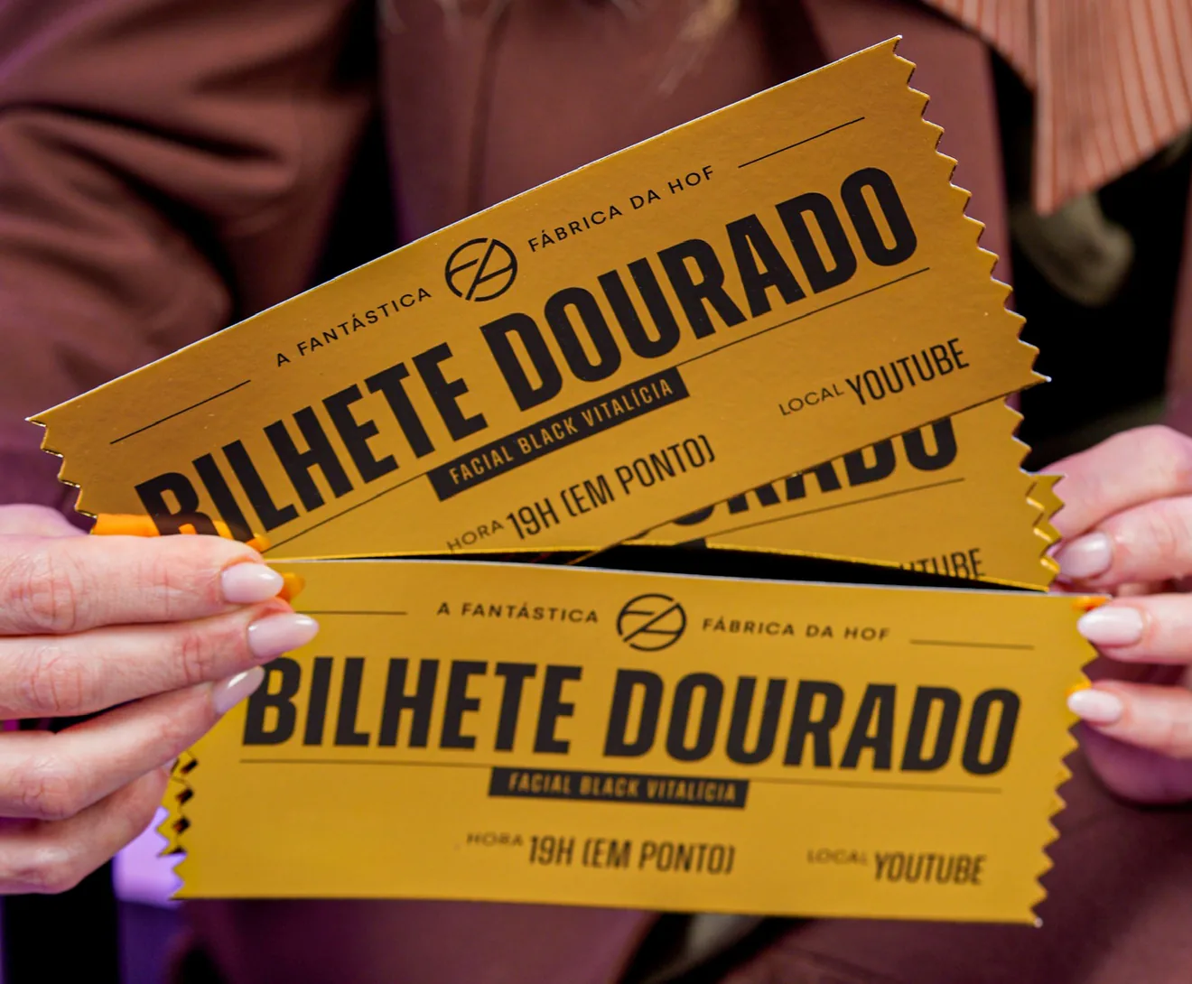 Dra. Camila Dias segurando bilhetes dourados da Fantástica Fábrica da HOF